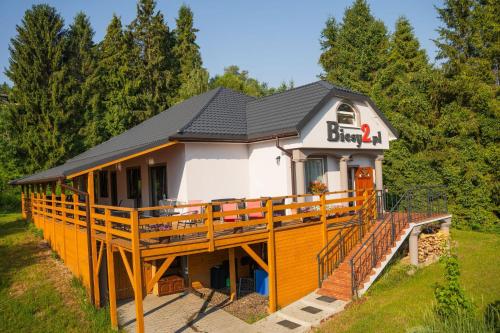 a large house with a large wooden deck at Biesy2 in Wetlina
