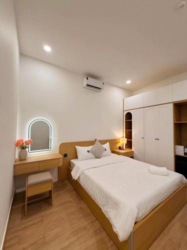 a bedroom with a bed and a desk and a mirror at Hue Glow Homestay in Thôn Lại Thê