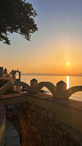 a view of the sunset from a bridge over the water at Silis Houses on the beach in Artemida
