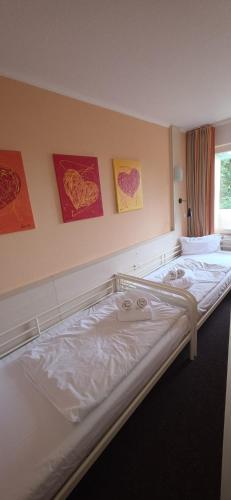 a bed in a room with paintings on the wall at Fereinwohnung an der Ostsee E312 in Schönberg