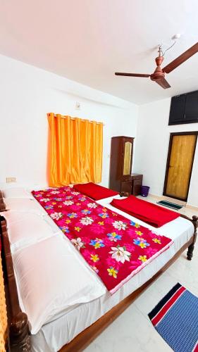 a bedroom with a large bed with flowers on it at Winter Flys in Anaviratty