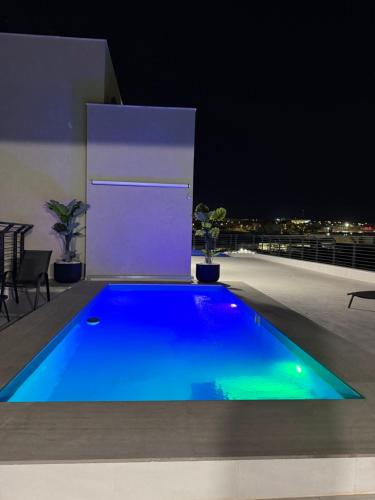 a blue swimming pool on a rooftop at night at פנטהאוז Siesta in Eilat