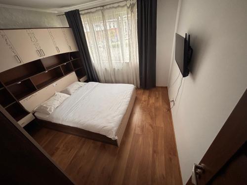 a small bedroom with a bed and a television at Mio Apartments Silver in Cluj-Napoca