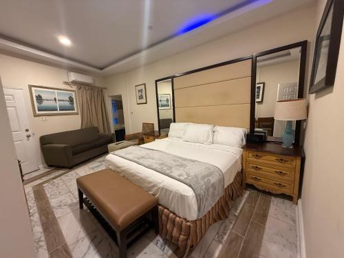 a bedroom with a large bed and a couch at Richcastle Hotel in Freetown