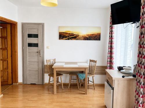a kitchen with a table and chairs in a room at Pokoje na Brzozowej 2 in Białogóra