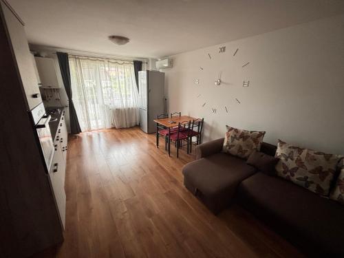 a living room with a couch and a clock on the wall at Mio Apartments Silver in Cluj-Napoca