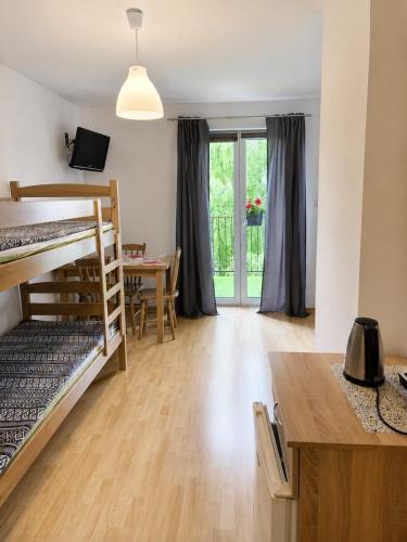 a room with bunk beds and a dining room with a table at Pokoje na Brzozowej 2 in Białogóra