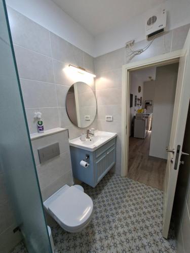 a bathroom with a toilet and a sink and a mirror at El Room Zimmer in El-Rom