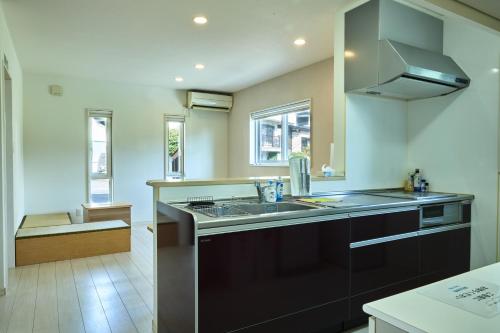 a large kitchen with a sink and a stove at 甘口派Stay in Tsurumakida