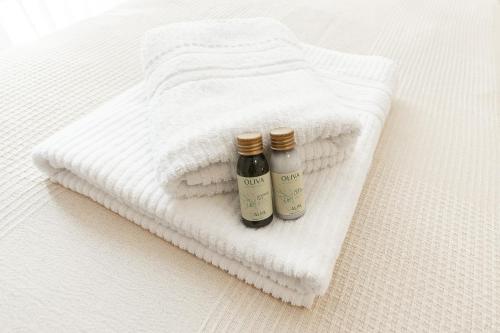 two bottles of essential oils sitting on a white towel at "Fiordolce" a due passi dal mare in Vado Ligure