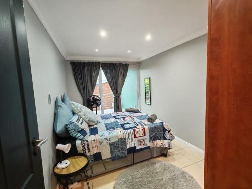 a bedroom with a bed and a window at Sea la vie at Jbay in Jeffreys Bay