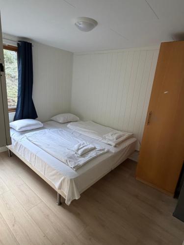 a white bed in a room with a window at Detached cozy house in Lom
