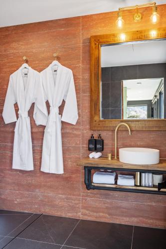 a bathroom with a white robe hanging on a wall at Jinibara Cottage in Conondale