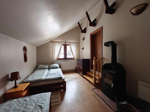 a bedroom with two beds and a stove in it at Gyulak Guesthouse in Izvoare