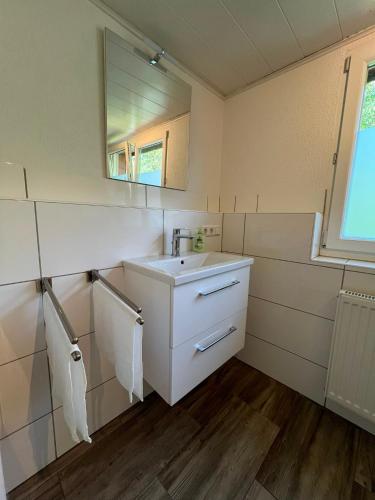 a white bathroom with a sink and a mirror at Monteurunterkunft Mosbach in Mosbach