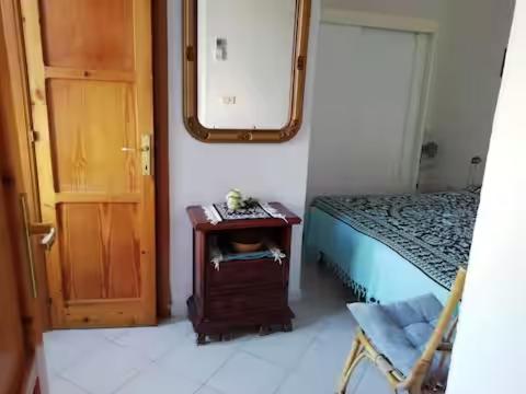 a bedroom with a bed and a table and a mirror at Casetta Calanave in Ventotene