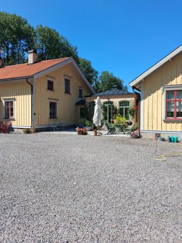 ein Haus mit einer Kiesauffahrt neben einem Gebäude in der Unterkunft Ängbacka in Rejmyre
