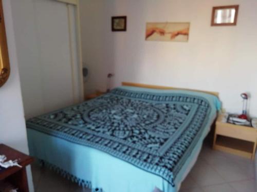 a bed in a bedroom with a blue blanket on it at Casetta Calanave in Ventotene