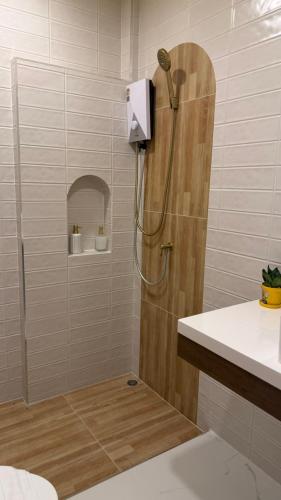 a shower in a bathroom with a sink and a shower at โรงแรม JP Lucky Lux Hotel in Ban Nong Samran