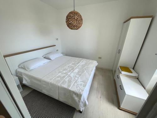 a white bedroom with a bed and a mirror at Frida in VeliGolji