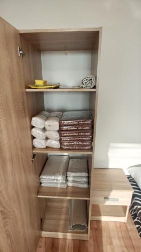 a closet with folded towels and books in it at Apartmán pro 3 osoby, Most M3 in Most