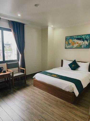 a hotel room with a bed and a chair at White Crown Hotel Ha Long in Ha Long