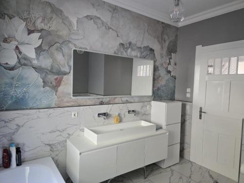 a bathroom with a sink and a tv on the wall at Villa Beckurts in Wernigerode