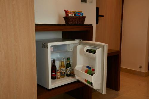 a small white refrigerator with drinks in it at Clickon Value Seven Hills in Chik Bānavar