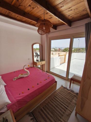a bedroom with a large bed and a large window at The Castle Hotel & studios in Dahab