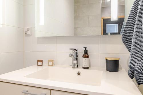 ein weißes Waschbecken in einem Badezimmer mit aaucet in der Unterkunft Terva23 in Hämeenlinna