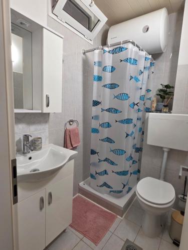 a bathroom with a shower curtain with fish on it at Breece Hideaway in Piran