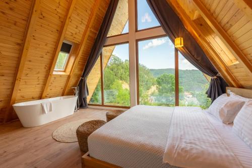 a bedroom with a bed and a large window at The Cliff Village in Comarnic
