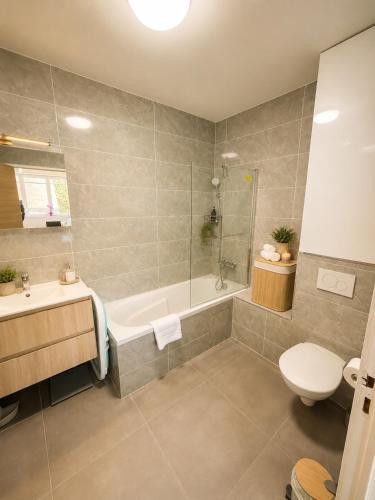 a bathroom with a tub and a toilet and a sink at Van Gogh's Garden in Auvers-sur-Oise