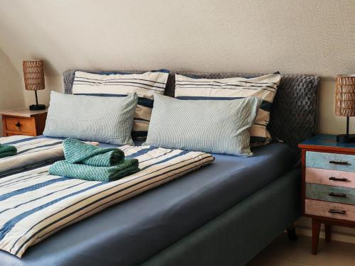 a bed with several pillows on top of it at Ferienhaus VILLA ZAUBERBLICK am Rennsteig Frankenwald FREISTEHEND naturnah HUNDEFREUNDLICH eingezäunt in Ludwigsstadt