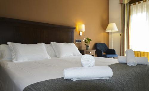 a hotel room with a large bed with towels on it at HOTEL Restaurante TurMo in Labuerda