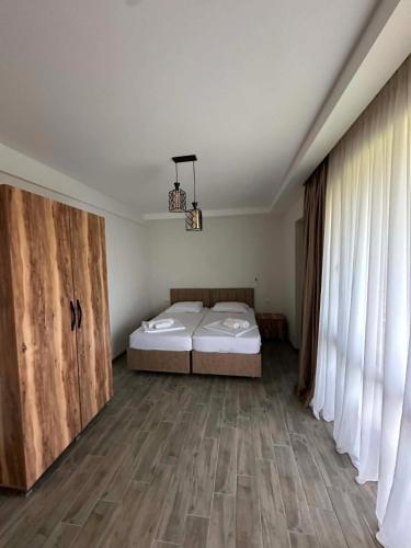 a bedroom with two beds and a large window at Modinakhe in Kobuleti