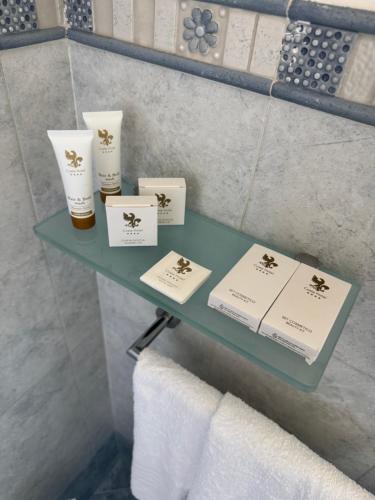 a shelf in a bathroom with towels and products on it at Costa Hotel in Pompei