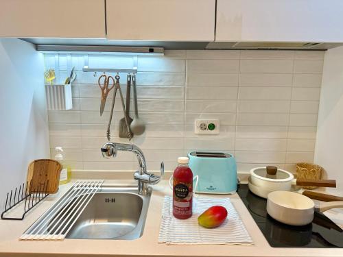a kitchen counter with a sink and a bottle of sauce at Mood Ocean 인천 영종도 in Chagyak-to
