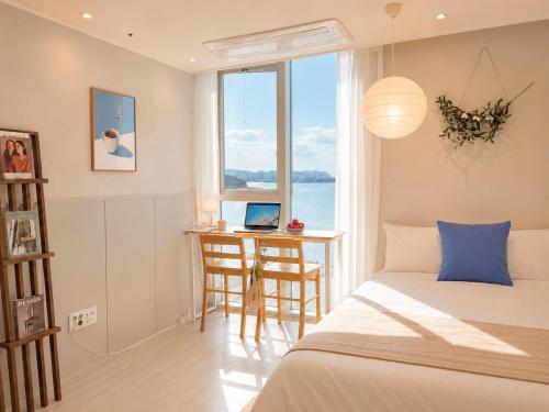 a bedroom with a bed and a desk and a window at Mood Ocean 인천 영종도 in Chagyak-to