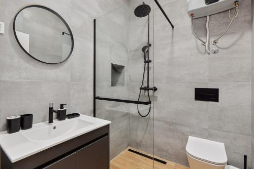 a bathroom with a shower and a sink and a mirror at Modern Studio Old Town by MN Property in Kotor