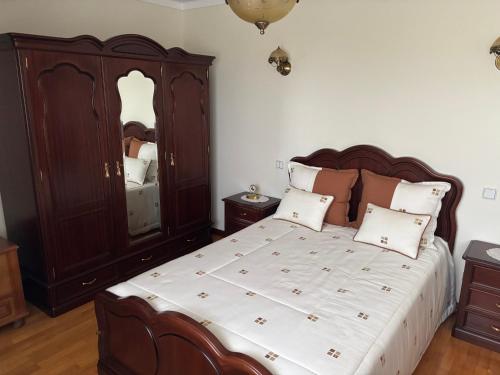 a bedroom with a large bed and a large mirror at SERRA e MAR in Murtais