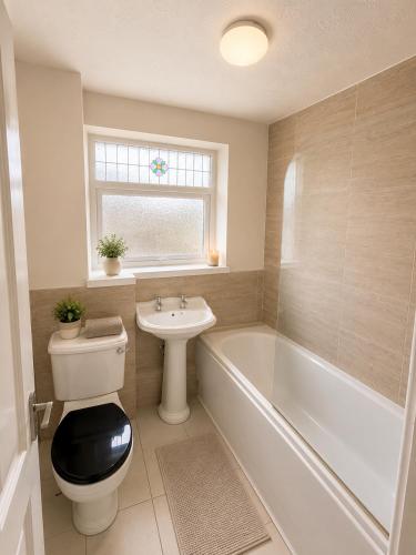 a bathroom with a toilet and a sink and a bath tub at Ellington Escape in Ellington