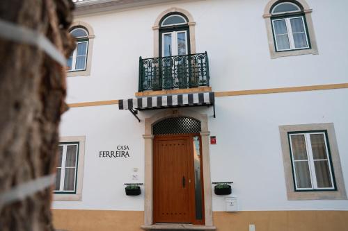 a building with a wooden door and a balcony at Casa Ferreira in Olaia