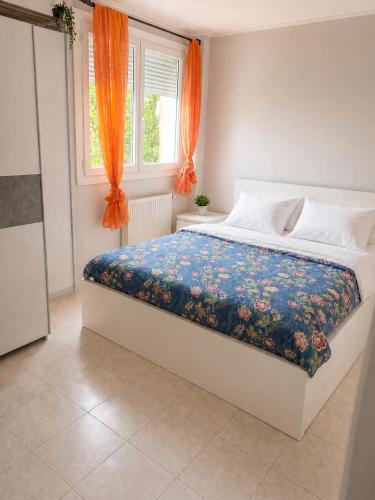 a bedroom with a large bed with an orange curtain at Prestige appart in Chalon-sur-Saône