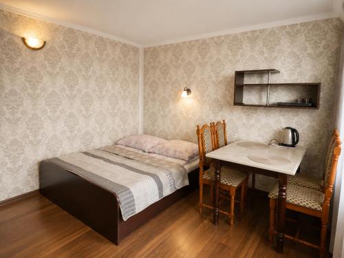 a small bedroom with a bed and a table at Magnat Dźwirzyno in Dźwirzyno