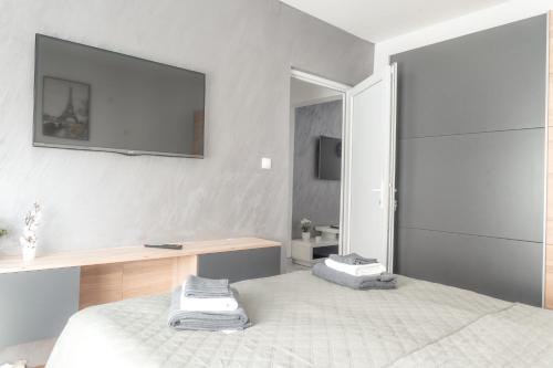 a bedroom with a bed with a tv on the wall at Nora Apartments in Jagodina