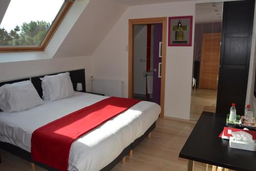 a bedroom with a large bed with a red blanket at Le Pic-Vert in Rang-du-Fliers