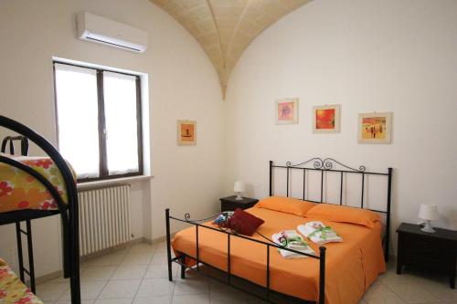 a bedroom with an orange bed and a window at Borgo Antico in Diso