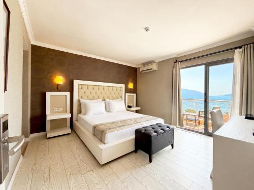 a bedroom with a large bed and a large window at Romance Beach Hotel in Marmaris