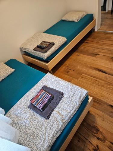 two beds sitting in a room with wooden floors at Ferienwohnung Sesvenna Davos in Davos
